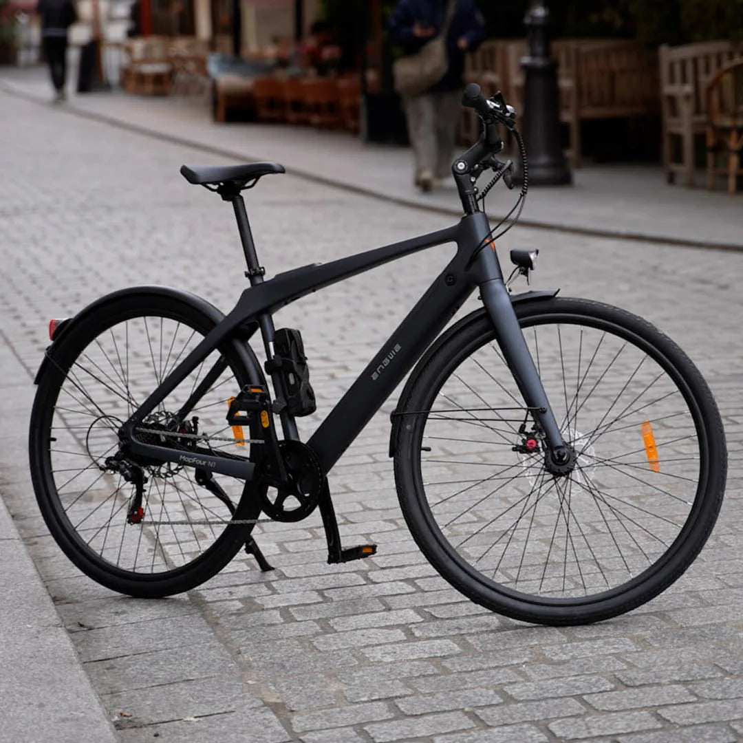 Elegantno črno Električno Kolo Engwe Mapfour N1 Air parkirano na tlakovani ulici.