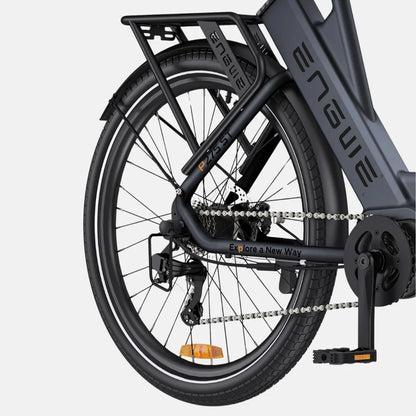 Na sliki je električno kolo znamke Engwe, model P275 ST. Vidna je zadnja stran kolesa, vključno z okvirjem, verigo, menjalnikom in pedalom. Kolo ima robustno konstrukcijo in je opremljeno s širokimi pnevmatikami ter nosilcem za dodatno opremo. Na okvirju je napis "Explore a New Way", kar nakazuje na namen raziskovanja in aktivnega preživljanja prostega časa.