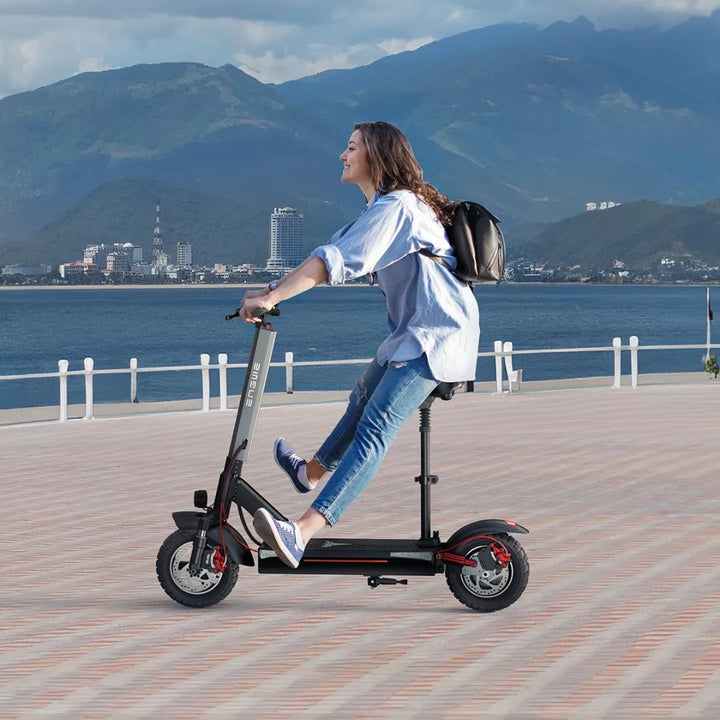 Oseba se vozi z električnim skirojem Engwe Y600 po slikoviti obalni poti.