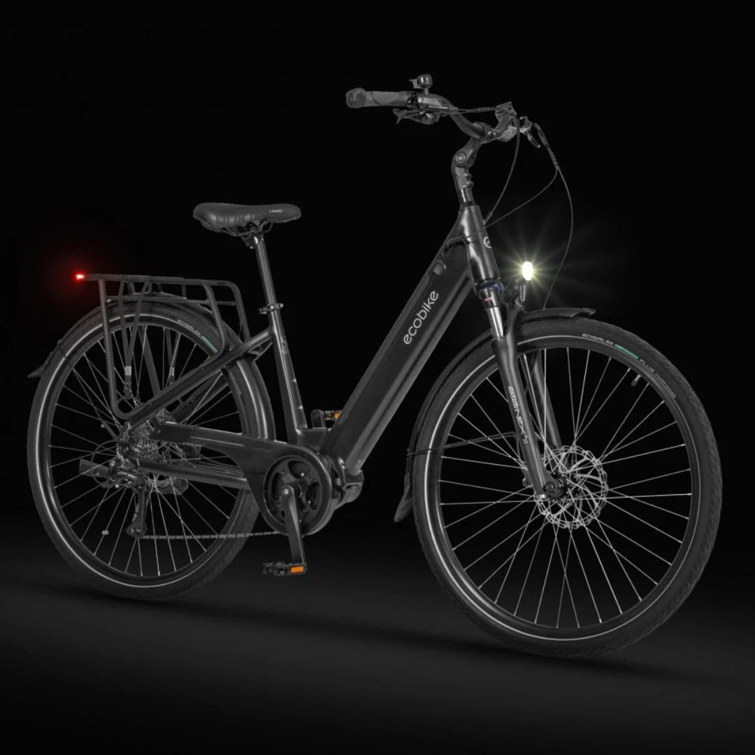 Izdelek na sliki je električno kolo znamke Ecobike, model LX 100. Kolo ima moderno črno zasnovo, opremljeno s sprednjim in zadnjim svetilom za boljšo vidnost. Vidna je tudi nosilna mreža na zadnjem delu, kar omogoča prevoz dodatne opreme. Kolo je zasnovano za udobno vožnjo in ima široke pnevmatike ter disk zavore.