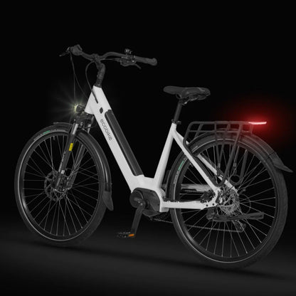 Izdelek na sliki je električno kolo znamke Ecobike, model LX 100. Kolo je zasnovano v elegantni beli barvi in ima močno konstrukcijo. Na sliki so vidni sprednji in zadnji del kolesa, vključno z LED lučmi za boljšo vidnost, ter nosilec za prtljago na zadnjem delu. Kolo je opremljeno z diskastimi zavorami in širokimi pnevmatikami, kar omogoča udobno vožnjo.