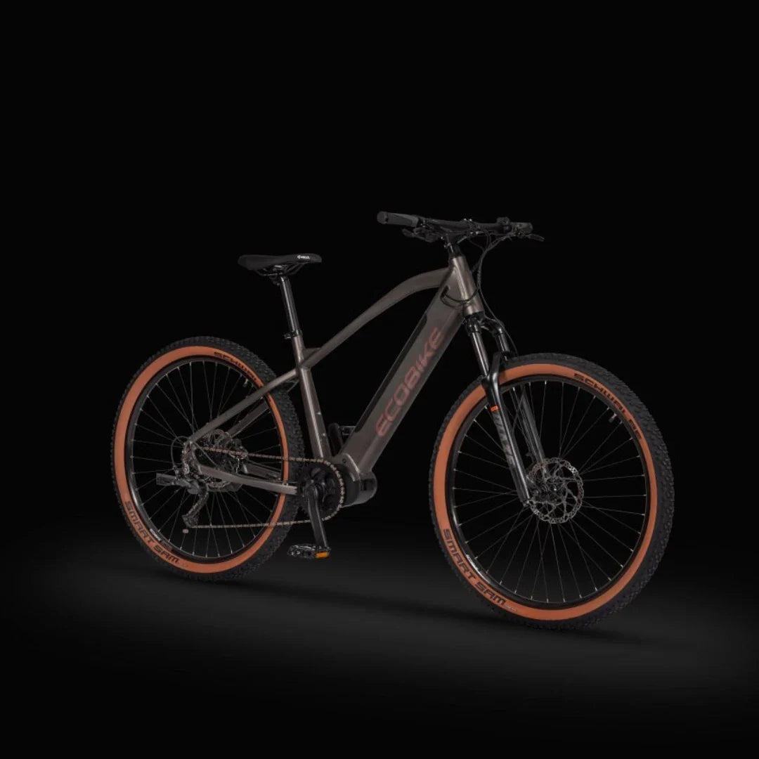 Izdelek je električno gorsko kolo znamke Ecobike, model SX300. Na sliki je vidno kolo s črnim okvirjem in značilnimi rjavimi plašči na kolesih. Kolo ima robustno zasnovo, primerno za vožnjo po zahtevnih terenih, ter je opremljeno s prednjim vzmetenjem in disk zavorami.