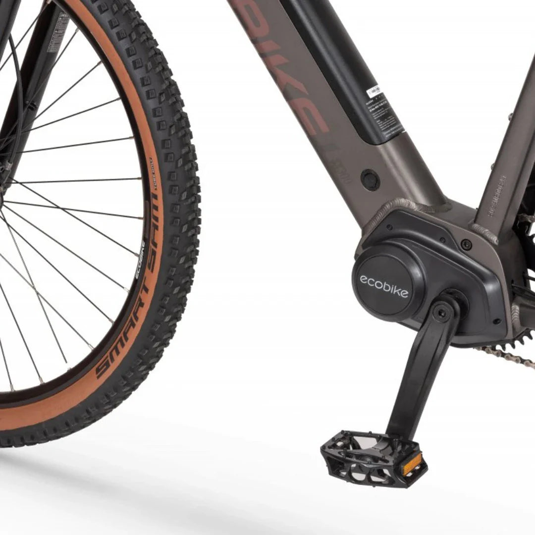 Izdelek je električno kolo znamke Ecobike, model SX300. Na sliki je vidna spodnja povezava kolesa, kjer je nameščen električni motor, ter pedal, ki je zasnovan za udobno vožnjo. Kolo ima robustne gume, kar nakazuje, da je primerno za vožnjo po zahtevnejših terenih.