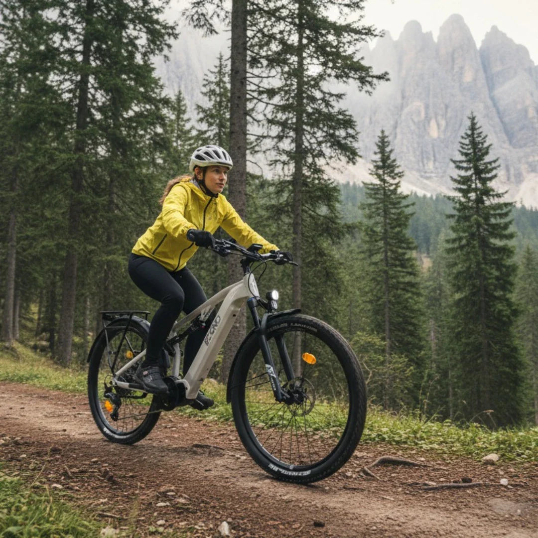 Izdelek je električno kolo, znamke Econo, model Pantera SUV C6 120. Na sliki vidimo kolesarko, oblečeno v rumeno jakno in črne hlače, ki vozi po gozdu. Okoli nje so visoka drevesa in v ozadju so vidne gorske skale, kar nakazuje na naravno okolje in primernost kolesa za terenske vožnje.