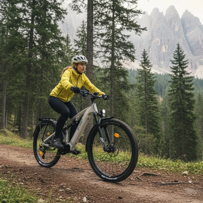 Na sliki je električno kolo znamke Econo, model Pantera C6 120. Kolo je vidno v gorskem okolju, kjer ga vozi oseba v rumeni jakni in čeladi. Opremljeno je z širokimi pnevmatikami, kar nakazuje na primernost za vožnjo po neravnem terenu. V ozadju so gozd in gorske pečine, kar ustvarja slikovito naravno okolje.