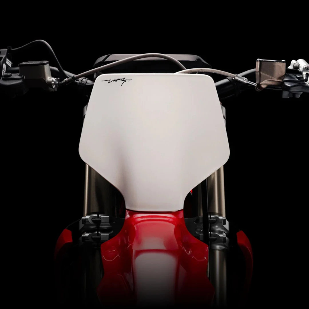 Od blizu posneto krmilo električnega motokros kolesa Stark Varg na črnem ozadju.