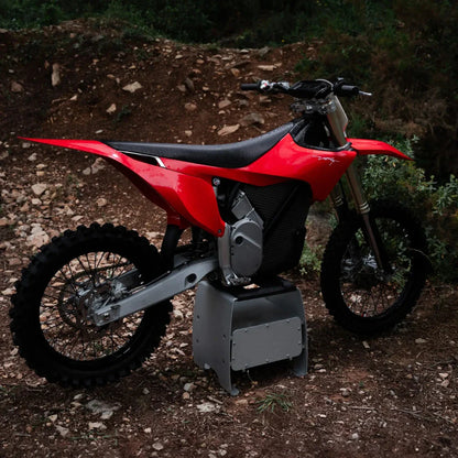 Električni motokros motor Stark Varg, ki se ponaša z elegantno rdečo obliko in robustnimi pnevmatikami.