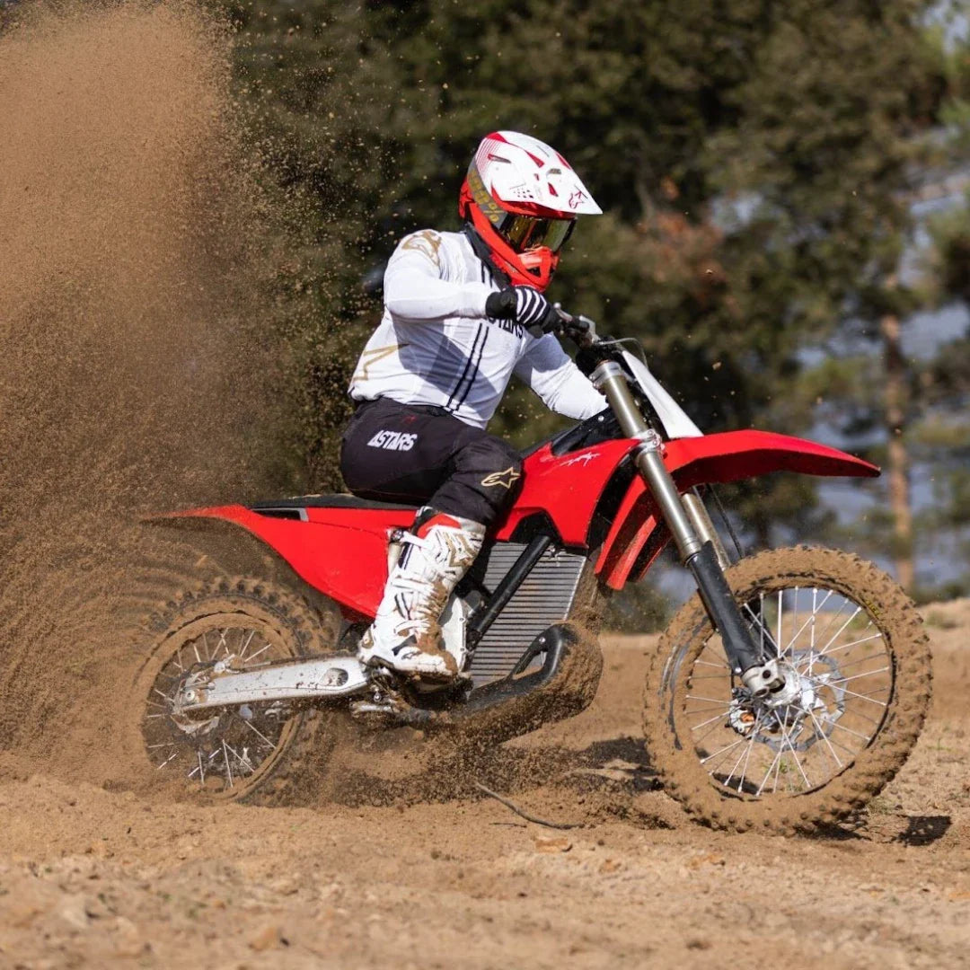 Voznik električnega motokros kolesa Stark Varg dviguje prah na stezi.