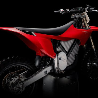 Električni motokros motocikel Stark Varg v osupljivi rdeči barvi na črnem ozadju.