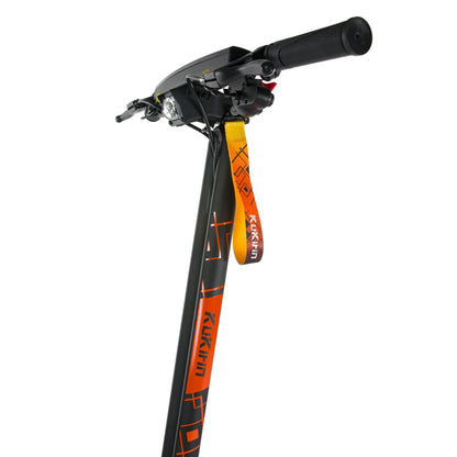 Na sliki je električni skiro znamke Kukirin, model G2 Ultra. Vidna je sprednja stran skiroja, kjer so ročaji, nadzorni gumb in luč. Barvna kombinacija črne in oranžne barve daje skiroju dinamičen videz.