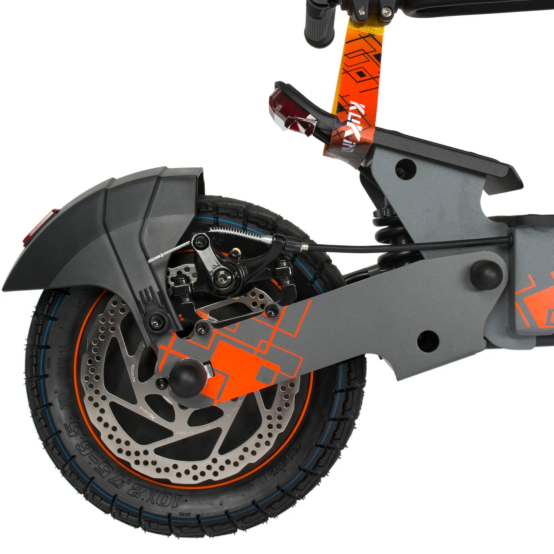 Na sliki je električni skiro znamke Kukirin, model G2 Ultra. Vidna je zadnja kolesna enota, ki vključuje disk zavore in pnevmatiko z značilnim vzorcem. Ohišje skiroja je v sivi barvi z oranžnimi detajli, kar daje dinamičen videz. Na zadnjem delu je tudi svetilka, ki povečuje vidnost med vožnjo.