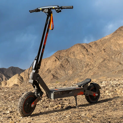 Izdelek na sliki je električni skiro, model Kukirin G2 Ultra. Na sliki je vidna robustna zasnova skiroja, ki je postavljen na kamenitem terenu, kar nakazuje njegovo primernost za vožnjo po zahtevnejših površinah. Ima široka kolesa in vzmetenje, kar prispeva k udobni vožnji. Rdeči detajli na črni strukturi dodajajo estetski pridih.