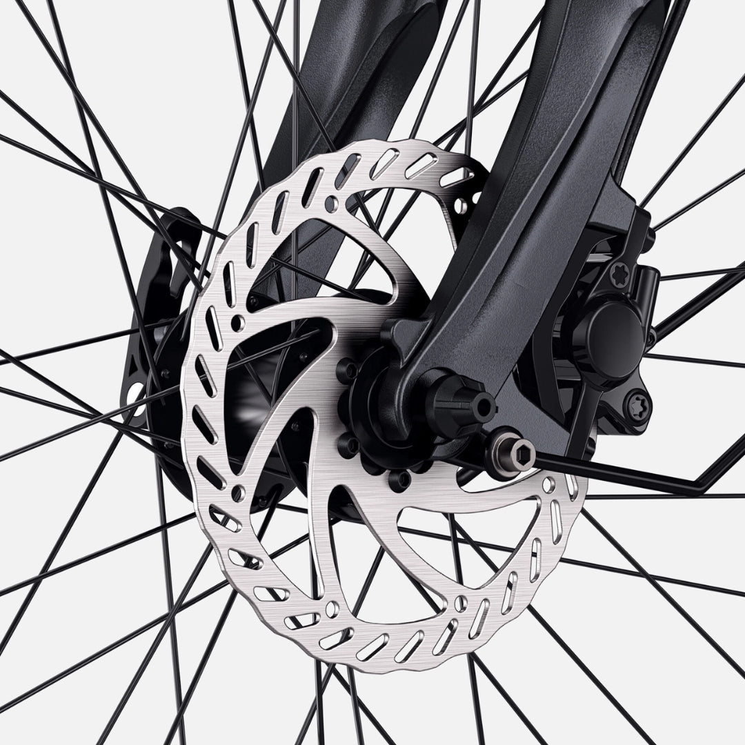 Na sliki je prikazano električno kolo znamke Engwe, model P275 SE. Osredotoča se na sprednji del kolesa, kjer je jasno viden disk zavore, ki je del sistema zaviranja. Disk je izdelan iz kovine in ima perforirano zasnovo za boljše hlajenje in učinkovitost zaviranja. Kolo je opremljeno z robustnimi vilicami in napetimi žicami, kar kaže na stabilnost in vzdržljivost.