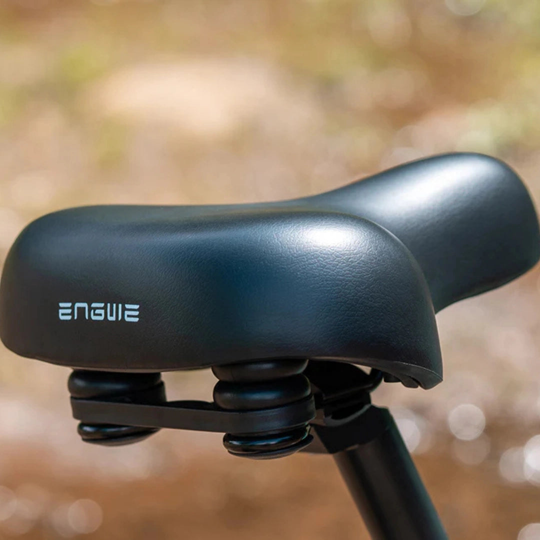 Izdelek je električno kolo, znamke Engwe, model EP-2 3.0 Boost. Na sliki je prikazano udobno kolo s širokim sedežem, ki ima vgrajene vzmeti za boljšo amortizacijo, kar omogoča prijetnejšo vožnjo. Sedež je črne barve in ima logotip znamke Engwe.