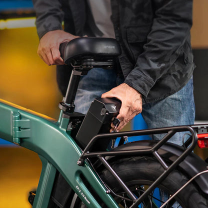 Na sliki je električno kolo znamke Engwe, model EP-2 3.0 Boost. Vidimo osebo, ki odstranjuje baterijo iz okvirja kolesa, kar nakazuje na enostavno zamenjavo ali polnjenje baterije. Kolo ima robustno zasnovo s širokimi pnevmatikami in nosilcem za prtljago.