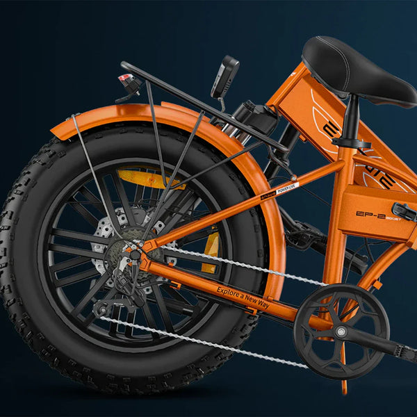 Na sliki je električno kolo znamke Engwe, model EP-2 Boost. Kolo je v živahni oranžni barvi in ima široke gume, kar nakazuje na njegovo primernost za različne terene. Vidna je tudi zadnja kolesna os, prestavna ročica in nosilec za prtljago, kar povečuje funkcionalnost kolesa.