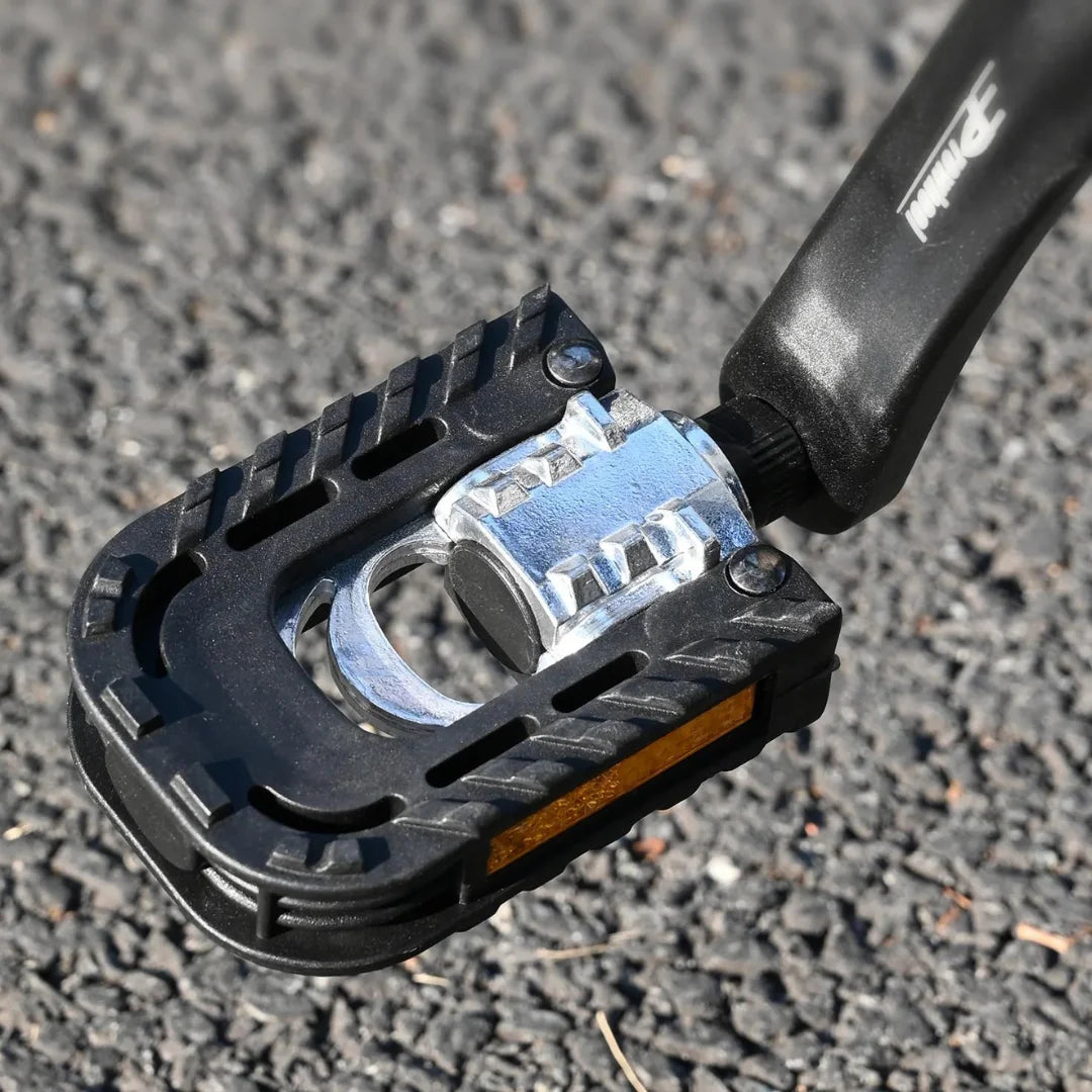 Od blizu posnet pedal na električnem kolesu Engwe Engine X, postavljen na teksturirano asfaltno površino.
