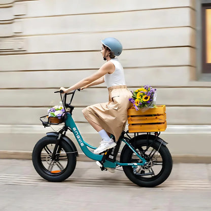 Na sliki je električno kolo znamke Engwe, model L20 Boost. Kolo ima široke pnevmatike in je opremljeno s košaro na zadnjem delu, v kateri so cvetlice. Na kolesu vozi ženska, ki nosi čelado in oblečena je v svetlo obleko. Ozadje prikazuje urbano okolje.