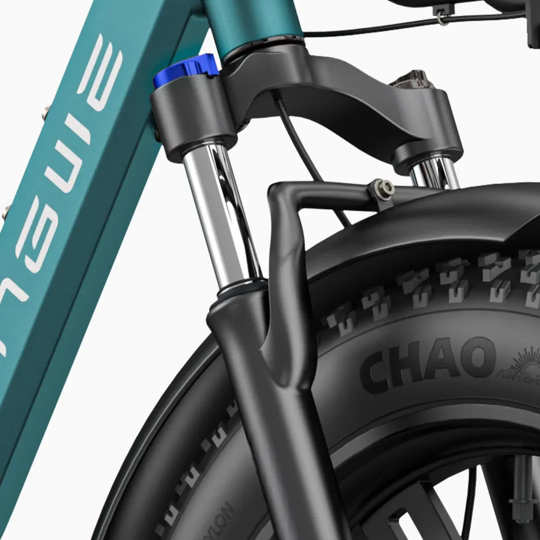 Izdelek na sliki je električno kolo, model Engwe L20 Boost. Vidna je sprednja vilica kolesa s kromiranimi cevmi in črnim platiščem, na katerem je označen vzorec pnevmatike "CHAO". Na vilici je tudi modra nastavitvena gumb, kar nakazuje možnost prilagajanja. Kolo je zasnovano za udobno vožnjo in stabilnost.
