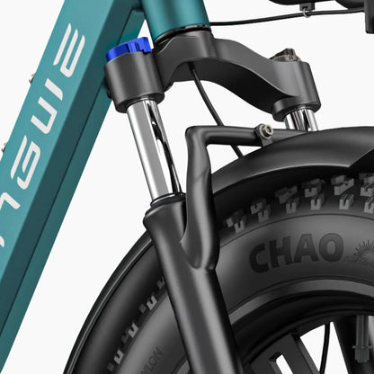 Izdelek na sliki je električno kolo, model Engwe L20 Boost. Vidna je sprednja vilica kolesa s kromiranimi cevmi in črnim platiščem, na katerem je označen vzorec pnevmatike "CHAO". Na vilici je tudi modra nastavitvena gumb, kar nakazuje možnost prilagajanja. Kolo je zasnovano za udobno vožnjo in stabilnost.