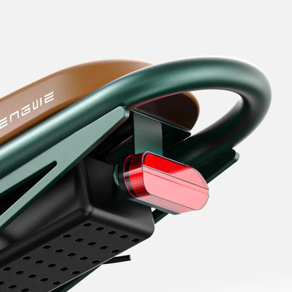 Izdelek je električno kolo, znamke Engwe, model M20. Na sliki je vidna zadnja lučka kolesa, ki je rdeče barve in je nameščena na okvirju. Ob tem je vidna tudi oblika in barva sedeža ter del okvirja, kar daje kolesu sodoben videz.