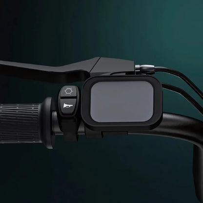 Izdelek je električno kolo, model Engwe M20. Na sliki je prikazan del krmila, ki vključuje zaslon in gumbe za upravljanje. Zaslon je prazen, ob njem pa sta gumb za luči in gumb za zvonec. Kolo ima ergonomsko oblikovane ročaje, kar nakazuje na udobno vožnjo.