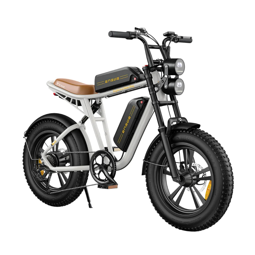 Izdelek na sliki je električno kolo, model Engwe M20. Kolo ima robustno zasnovo s širokimi gumami, kar omogoča dobro stabilnost in oprijem. Na sliki so vidni tudi dva sprednja svetila ter baterije, ki so nameščene na okvirju, kar nakazuje na električni pogon. Sedež je udoben in v svetlo rjavi barvi, kar dodaja estetski pridih.