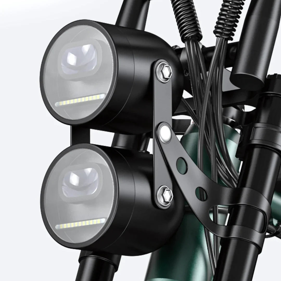 Izdelek je električno kolo, znamke Engwe, model M20. Na sliki so prikazana dva sprednja svetila, nameščena na okvirju kolesa, kar omogoča boljšo vidljivost med vožnjo. Vidni so tudi deli okvirja in kabli, ki so del električnega sistema kolesa.