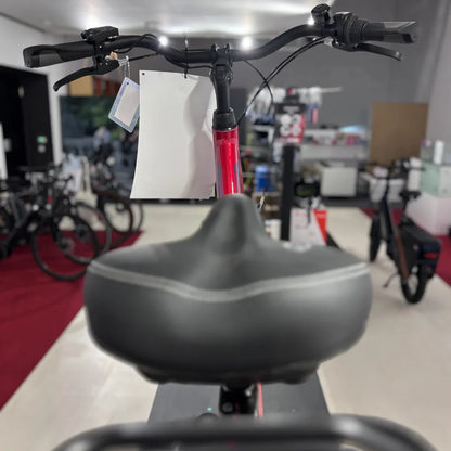 Izdelek na sliki je električno kolo, znamke Fischer, model Cita 1.0. Na sliki je vidna sprednja stran kolesa, vključno s krmilom in sedežem. Kolo je v rdeči barvi, na krmilu pa je pritrjena oznaka. V ozadju so vidna tudi druga kolesa v trgovini.