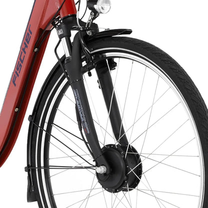 Izdelek je električno kolo znamke Fischer, model Cita 1.0. Na sliki je prikazan sprednji del kolesa, ki vključuje prednjo vilico, kolo z značilnim vzorcem pnevmatike ter električni motor, ki je integriran v prednjem kolesu. Vidna je tudi svetilka, kar nakazuje na funkcionalnost za vožnjo v slabših svetlobnih pogojih.