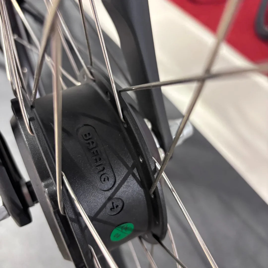 Izdelek je električno kolo, znamke Fischer, model Cita 1.0. Na sliki je prikazan del kolesa, natančneje motor, ki je vgrajen v zadnjem kolesu. Vidni so tudi žičniki in del okvirja, kar nakazuje na robustno konstrukcijo kolesa. Motor je označen z logotipom Bafang, kar je znana blagovna znamka za električne pogone.