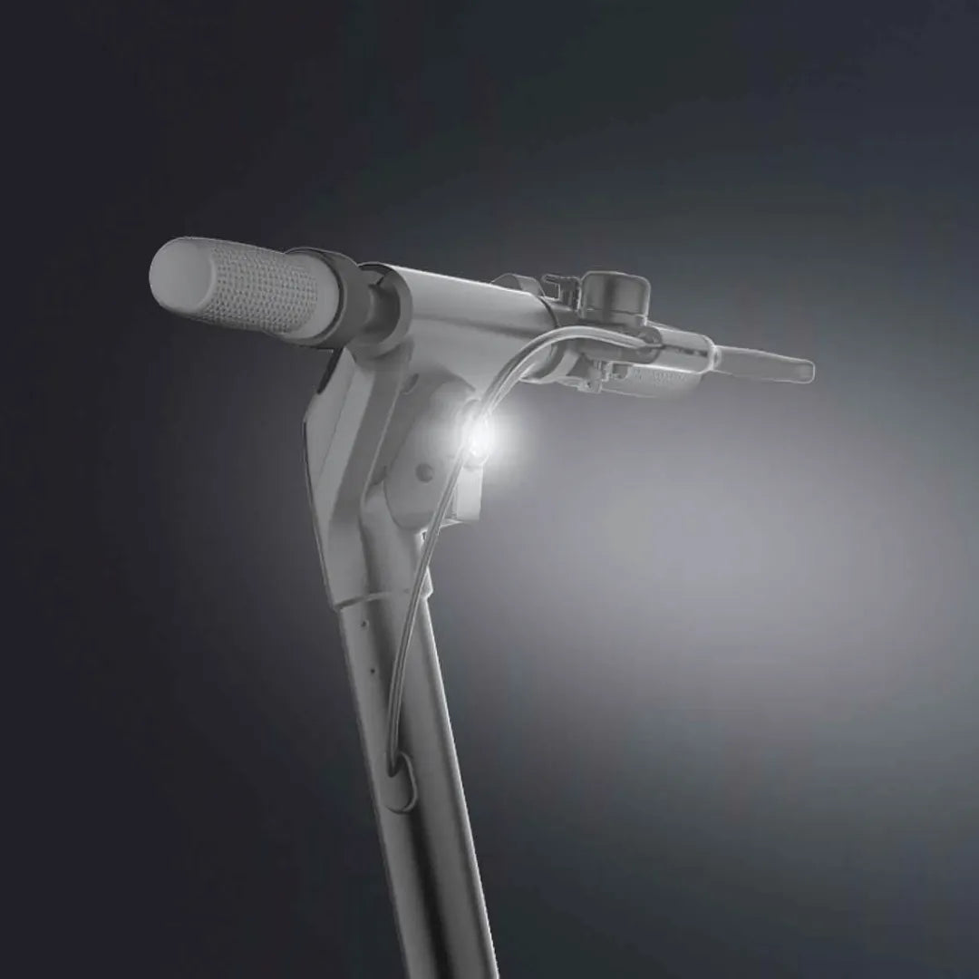 Na sliki je električni skiro znamke Joyor, model Litego. Vidna je ročica skiroja z ergonomskim oprijemom ter svetilka, ki je nameščena na sprednjem delu, kar omogoča boljšo vidljivost med vožnjo v temnejših razmerah. Ozadje slike je temno, kar poudarja obliko in detajle skiroja.