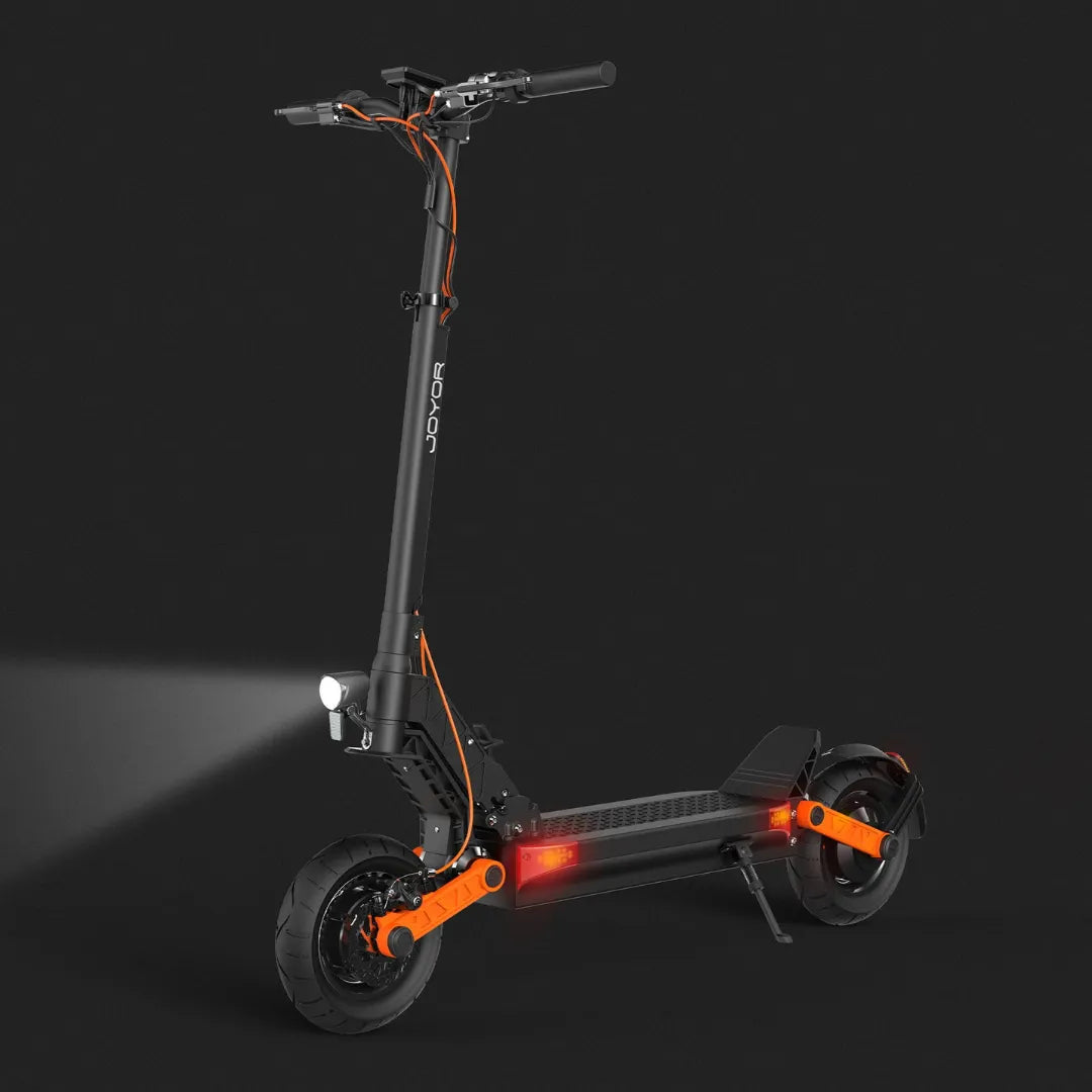 Električni skiro Joyor S10 S Z na temnem ozadju, z živahnimi oranžnimi poudarki in lučmi.