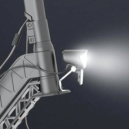 Izdelek je električni skiro, znamke Joyor, model S10-S. Na sliki je prikazan del skiroja, kjer je nameščen sprednji svetlobni vir, ki je usmerjen naprej. Vidna je tudi struktura okvirja skiroja ter kabli, ki so povezani z lučjo. Celoten dizajn je sodoben in funkcionalen.