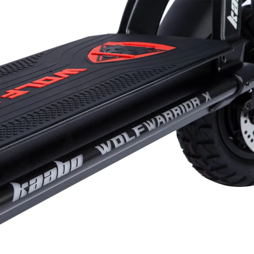 Izdelek je električni skiro, znamka je Kaabo, model pa Wolf Warrior X Plus. Na sliki je vidna platforma skiroja z izrazitim logotipom "WOLF" in imenom modela "WOLF WARRIOR X" na stranski cevi. Platforma ima teksturirano površino za boljši oprijem, ob straneh pa so vidne robustne pnevmatike, kar nakazuje na njegovo primernost za različne terene.