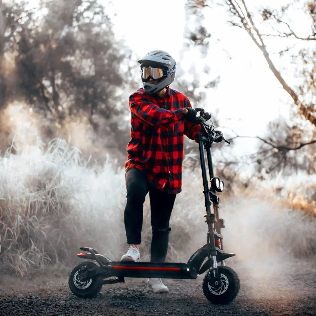 Oseba s čelado vozi električni skiro Kaabo Wolf Warrior X Plus po megleni poti.