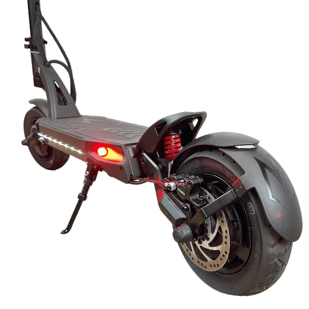 Izdelek je električni skiro, znamke Kaabo, model Mantis 10 Plus. Na sliki je prikazan zadnji del skiroja, ki vključuje široko zadnje kolo, disk zavore in rdečo luč, kar nakazuje na njegovo funkcionalnost in varnost. Opremljen je tudi s sistemom vzmetenja, kar pripomore k udobnejši vožnji.