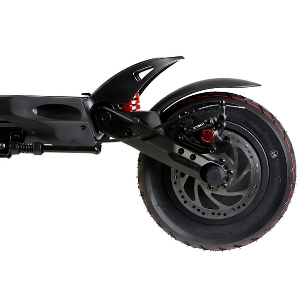 Izdelek na sliki je električni skiro, model Kaabo Mantis 10 Plus. Na sliki je prikazan zadnji del skiroja, vključno z zadnjim kolesom, vzmetenjem in zavorami. Kolo ima široko pnevmatiko z izrazitim profilom, kar nakazuje na dobro oprijemljivost, medtem ko je vzmetenje zasnovano za udobno vožnjo po različnih površinah.