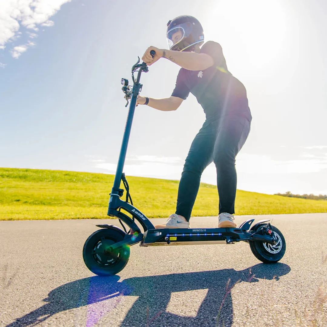 Oseba se vozi z električnim skirojem Kaabo Mantis 10 Plus po sončni, odprti poti.