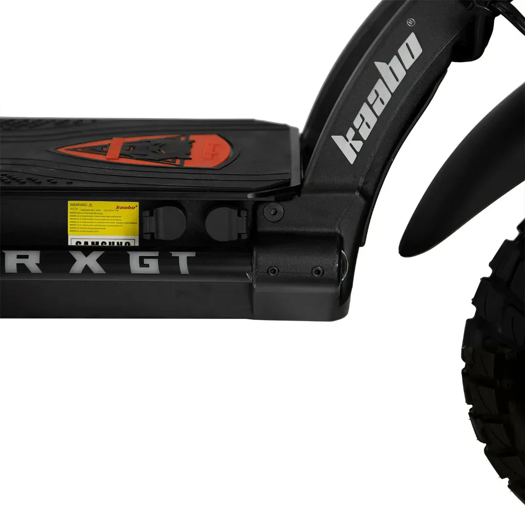 Izdelek je električni skiro, znamke Kaabo, model Wolf Warrior X GT. Na sliki je vidna platforma skiroja z oznakami in delom za baterijo, ki je opremljena z robustnimi pnevmatikami, kar nakazuje na njegovo zmogljivost in primernost za različne terene. Vidna je tudi zaščita za prtljažnik in detajli, ki prispevajo k estetiki in funkcionalnosti skiroja.