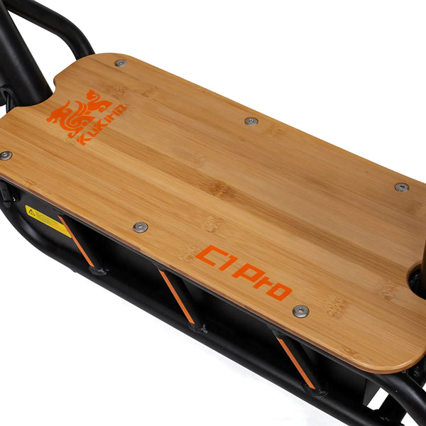 Izdelek na sliki je električni skiro znamke Kukirin, model C1 Pro. Na sliki je vidna lesena platforma, ki je del skiroja, z jasno označenim imenom modela in logotipom znamke. Platforma je zasnovana tako, da nudi udobno in stabilno vožnjo.