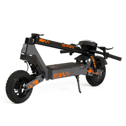 Izdelek je električni skiro, znamke Kukirin, model G2. Na sliki je prikazan skiro v zloženem stanju, kar omogoča enostavno prenašanje. Ima robustno konstrukcijo, široke gume in zložljive ročaje, kar nakazuje na praktičnost in udobje pri uporabi. Barvna kombinacija črne in oranžne dodaja športen videz.