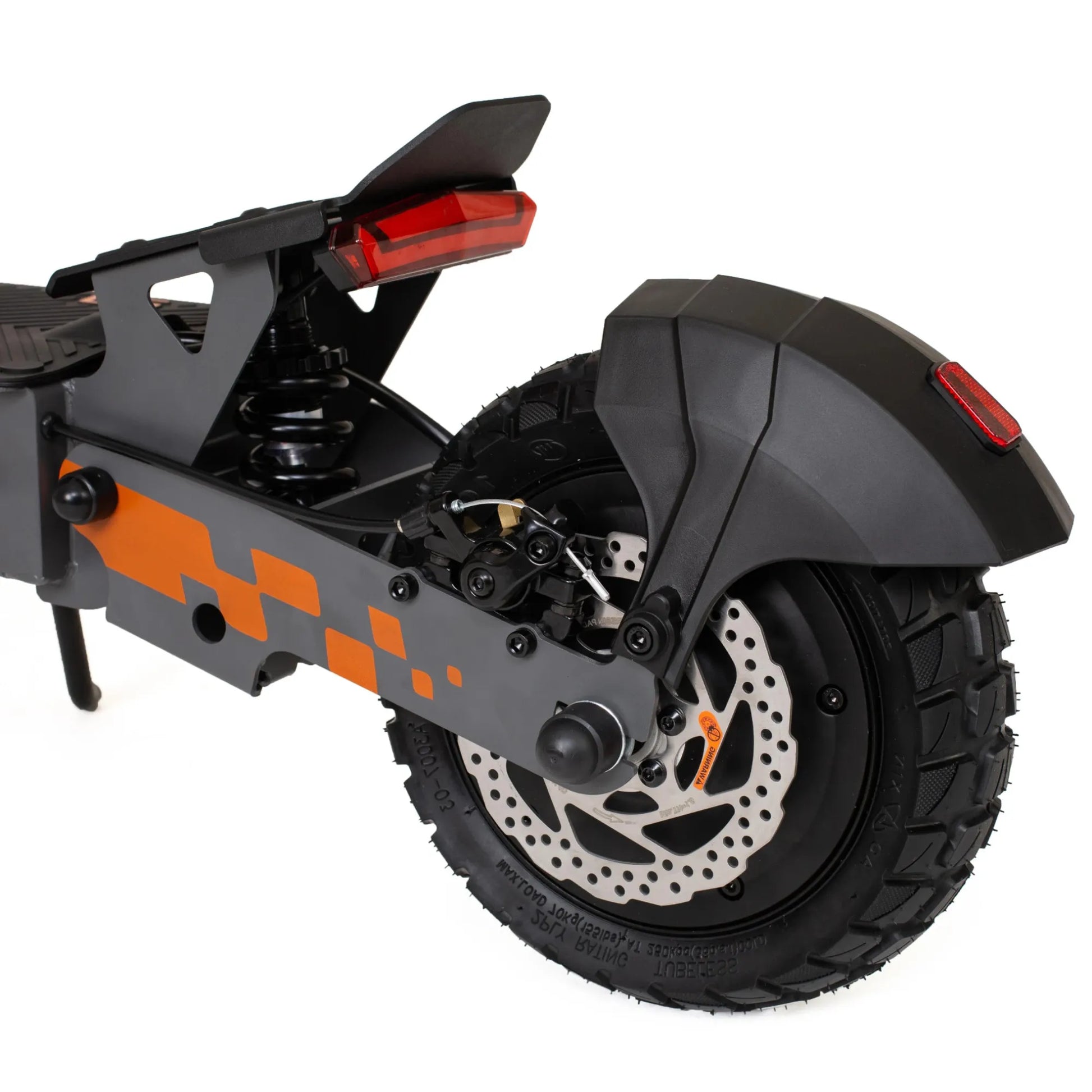 Izdelek na sliki je električni skiro, model Kukirin G2. Na sliki je vidna zadnja stran skiroja, kjer so prikazani zadnji luči, vzmetenje in zadnje kolo. Kolo ima robusten profil, kar nakazuje na dobro oprijemljivost, medtem ko je okvir skiroja zasnovan z elementi v sivi in oranžni barvi.