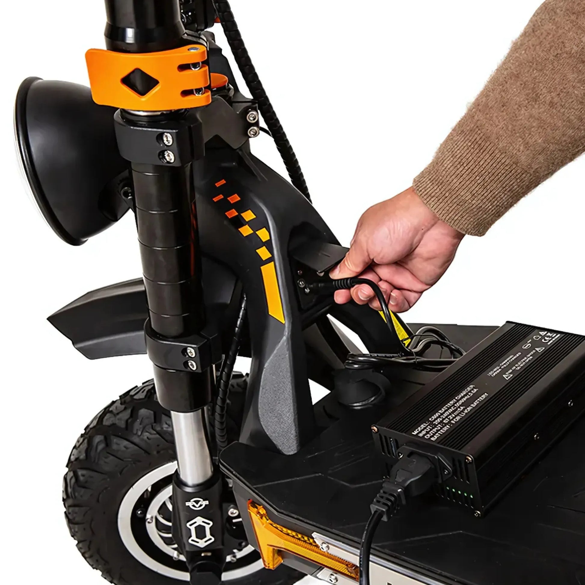 Oseba priklopi polnilec na električni skiro Kukirin G4 Max za polnjenje.