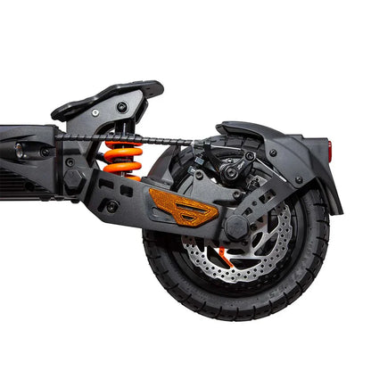 Izdelek na sliki je električni skiro, model Kukirin G2 Master. Na sliki je prikazan zadnji del skiroja, ki vključuje vzmetenje v svetlo oranžni barvi, disk zavoro in robustno zadnje kolo. Vidna je tudi struktura okvirja, ki je zasnovana za stabilnost in udobno vožnjo.