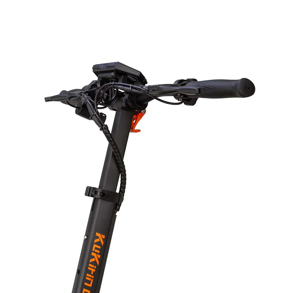 Na sliki je električni skiro znamke Kukirin, model G2 Master. Vidna je sprednja del skiroja, ki vključuje krmilo s prijemali in nadzorno ploščo. Na krmilu so tudi kabli, ki so povezani z električnim sistemom skiroja. Barva skiroja je večinoma črna, z oranžnimi detajli na imenu znamke.