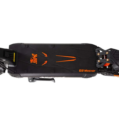 Izdelek je električni skiro, znamke Kukirin, model G2 Master. Na sliki je vidna zgornja površina skiroja, ki je v črni barvi z oranžnimi detajli. Površina ima teksturiran vzorec za boljši oprijem, ob robu pa je vidna tudi oznaka modela. Na eni strani je prikazan prostor za baterijo, kar nakazuje na električni pogon.