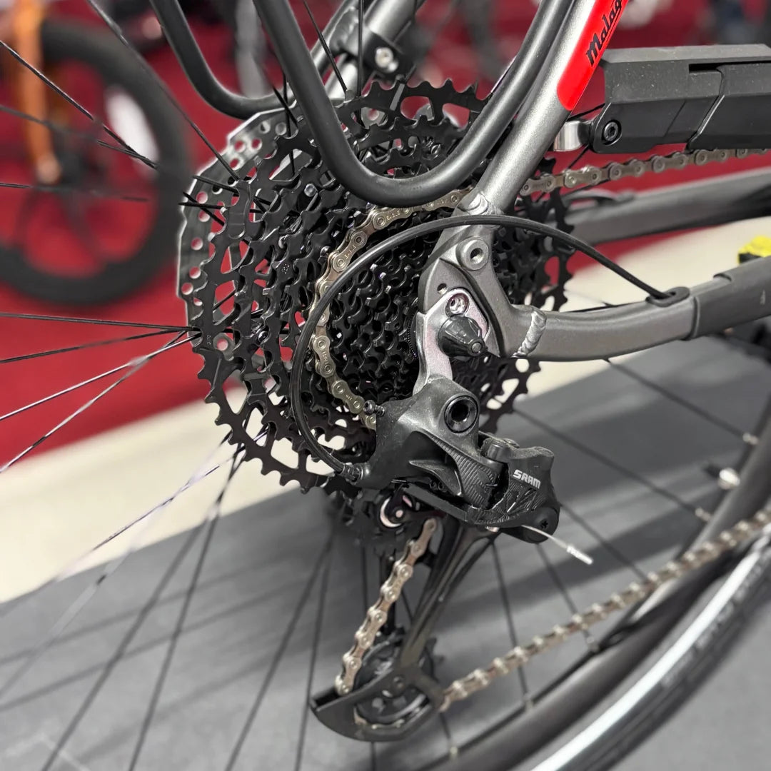 Izdelek je električno kolo znamke Malaguti, model Bolonina. Na sliki je prikazan zadnji del kolesa, kjer so vidni menjalnik in verižnik. Menjalnik je znamke SRAM, kar nakazuje na kakovostno opremo. Kolo je zasnovano za učinkovito prestavljanje in vožnjo po različnih terenih.