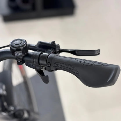 Izdelek je električno kolo znamke Malaguti, model Bolonina. Na sliki je prikazan del krmila, ki vključuje ročico za zaviranje, ročaj in zvonec. Ročaji so oblikovani za udoben oprijem, kar omogoča boljšo kontrolo med vožnjo.