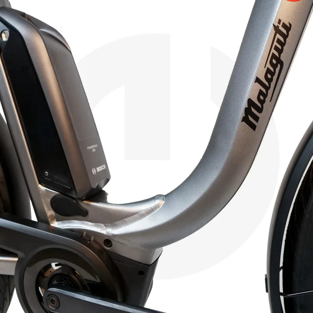 Izdelek na sliki je električno kolo znamke Malaguti, model Bolonina. Na sliki je vidna baterija Bosch, ki je nameščena na okvirju kolesa, kar nakazuje na električni pogon. Oblika okvirja je moderna in aerodinamična, kar je značilno za sodobna električna kolesa.